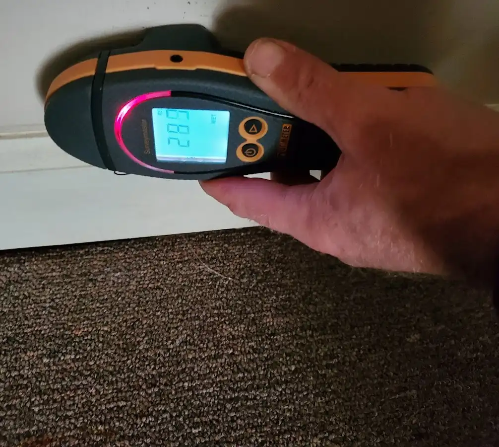 Moisture detection at baseboard during Storm Damage Restoration in August